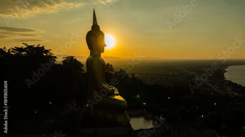 Aerial view at sunset above the Mekong river in Laos revealing Pakse city golden giant buddha