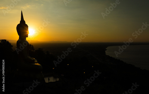 Aerial view at sunset above the Mekong river in Laos revealing Pakse city golden giant buddha