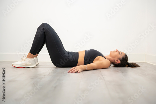 Woman preparing for glute bridge exercise on floor