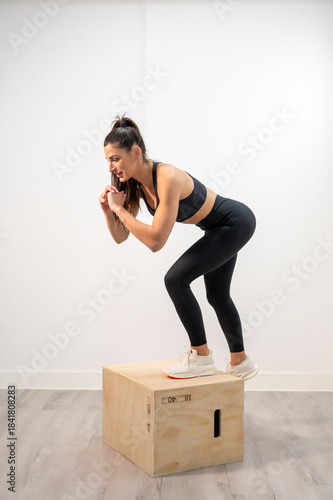 Woman performing powerful box jump exercise