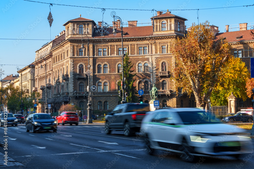 Fototapeta premium View of city streets, architecture, houses and traffic, random people on the sidewalk, city life in Budapest, Hungary, Heroes Square