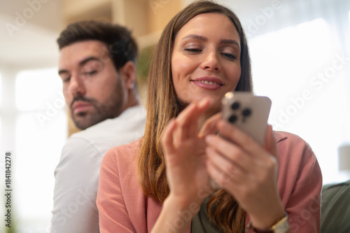 Quadro su tela Man feeling jealous watching woman using phone