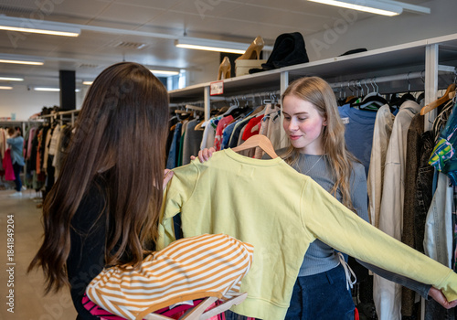 Photos Women choosing clothes together in secondhand store