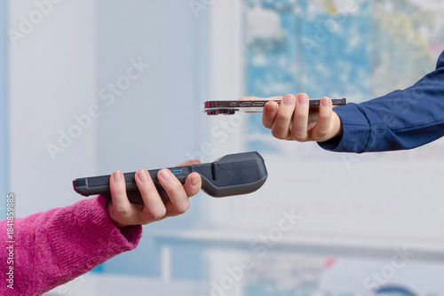 Photography POS terminal and smartphone approach each other for a tap-to-pay interaction, ca