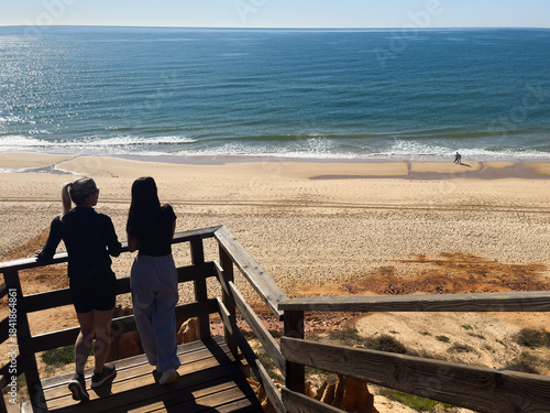 mother and daughter walking on the beach portugal