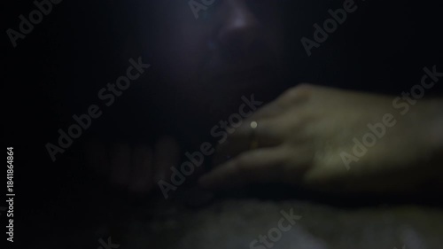 Explorer Navigating Dark Cave With Headlamp