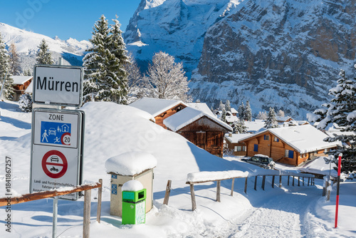 Fresh winter snow covering the alpine village and surrounding peaks, creating a bright and peaceful mountain landscape