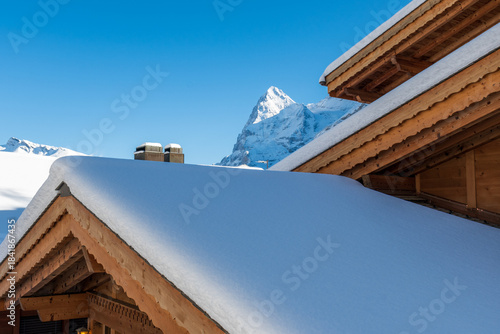 Fresh winter snow covering the alpine village and surrounding peaks, creating a bright and peaceful mountain landscape