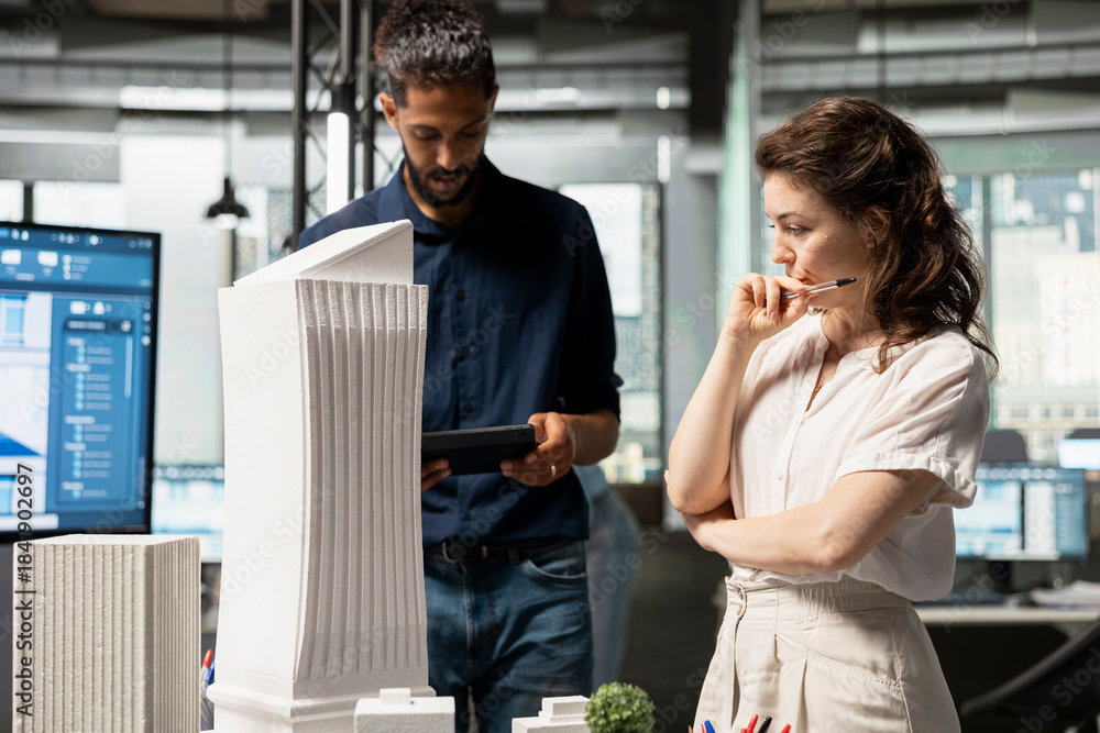 Obraz premium Diverse real estate developers reviewing smart city design and buildings layout, city planning for modern residential infrastructure and long term property investment strategies.