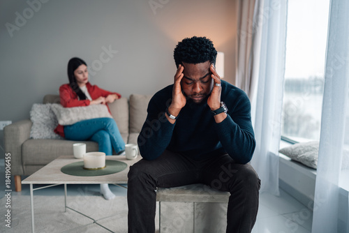 Couple experiencing conflict, man suffering from stress and headache