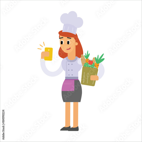 Happy female chef holding a bag of fresh vegetables and checking a smartphone app