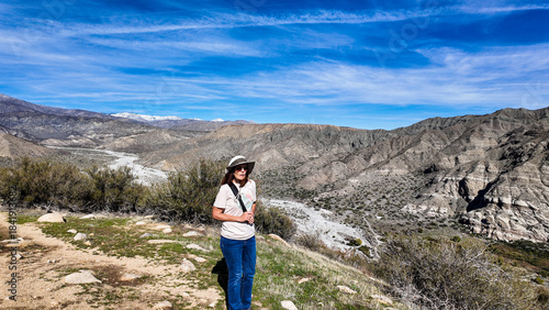 A Woman Geologist on the Trail in the Whitewater Canyon in California evaluating weathering, Erosion, and Runoff along the Whitewater River near Palm Springs to evaluate flood potential