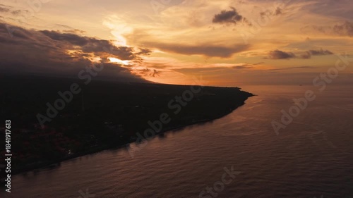 Golden light from a dramatic sunset illuminating the sky above the Bali sea coast
