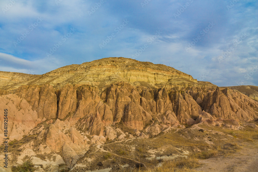 Fototapeta premium Cappadocia valley in Turkey. Cappadocia rock formation sites and chimneys Love Valley. Tuff volcanic rock pillars and mushrooms in the museum under open sky in Cappadocia turkish famous tourist sight
