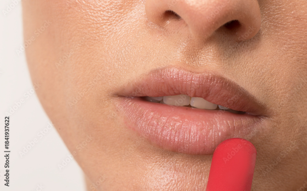 Naklejka premium Elegant Woman Applying Red Lipstick Close Up. Beauty face. Lips. Sensual. 