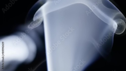 Abstract swirling wisps of smoke on black.