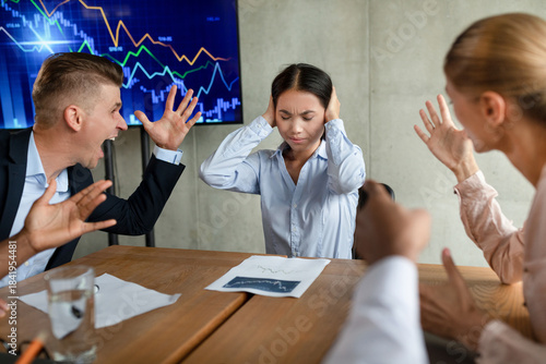 Cuadro en lienzo In an office conference meeting, several aggressive colleagues are shouting at a young Asian female employee