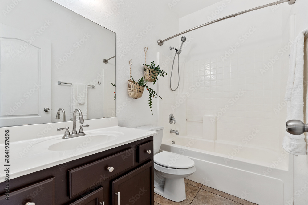 Fototapeta premium A welldesigned bathroom with a sink, toilet, bathtub, and mirror