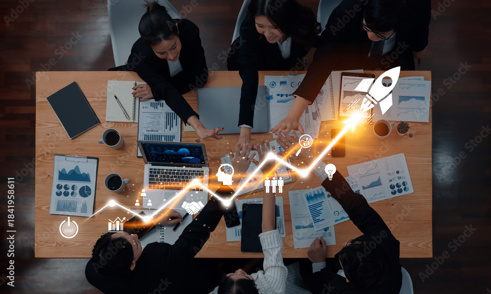 Fototapeta premium A diverse business team engages in a strategy meeting, focusing on growth and innovation. Visuals of digital analytics and a rocket reflect their ambitious objectives. Trope