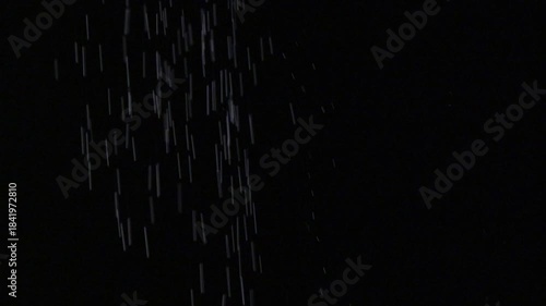 黒背景で粉糖を振り掛けるシーン