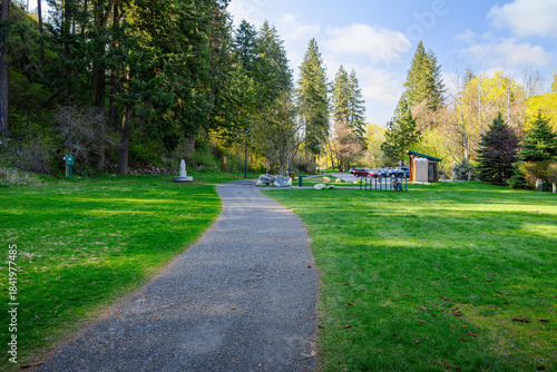 Fototapeta Naklejka Na Ścianę i Meble -  A path leading to the public parking area alongside Tubbs Hill at the Sanders Beach park in downtown Coeur d'Alene, Idaho.