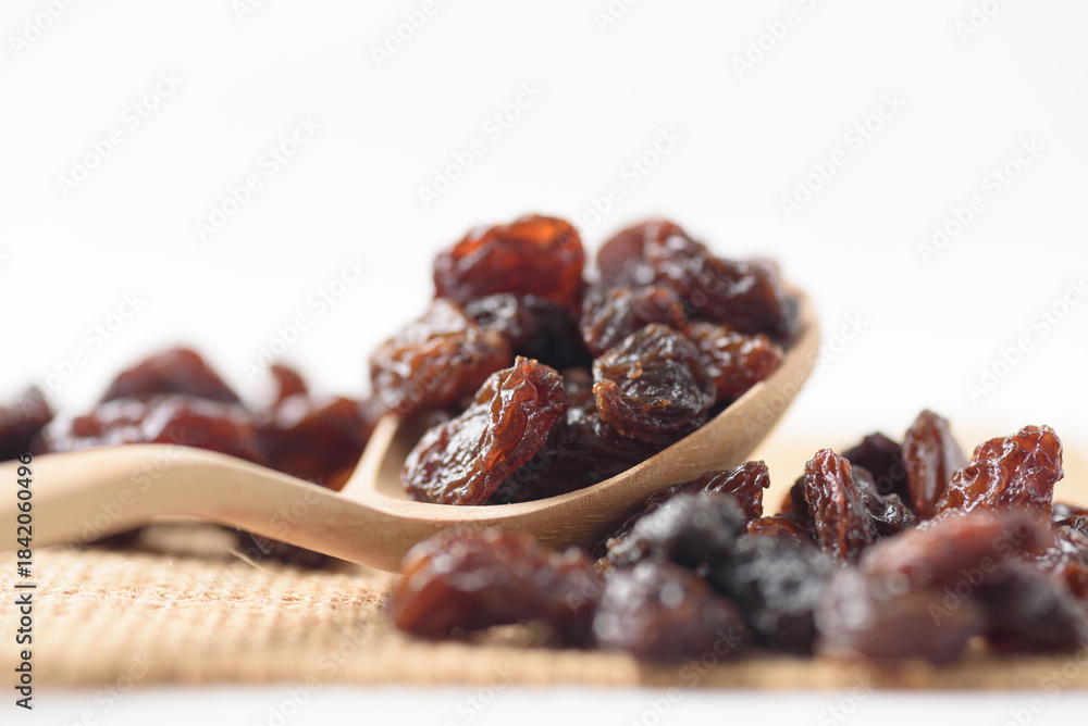 Fototapeta premium Dried dark raisins on a white background. A healthy snack