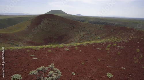 Meke lake volcano crater showing its red soil and green vegetation under a clear sky in Turkey