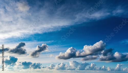 Vivid Blue Sky with Scattered White Cumulus Clouds on a Bright Sunny Day, Atmospheric Landscape Background Showing Clear Weather and Soft Cloud Formations