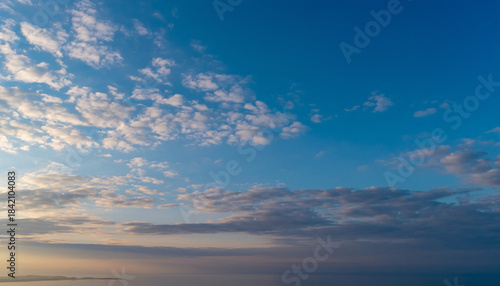 Vivid Blue Sky with Scattered White Cumulus Clouds on a Bright Sunny Day, Atmospheric Landscape Background Showing Clear Weather and Soft Cloud Formations