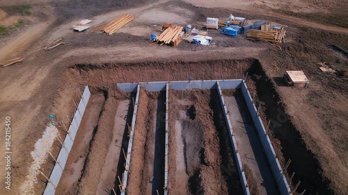 Construction site showing foundation for a new building with multiple compartments.