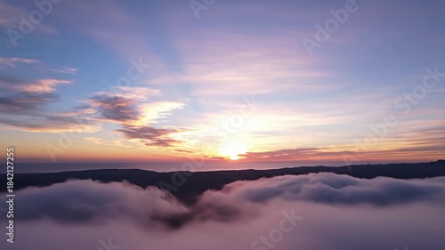 Majestic Sunrise Over Fog-Laden Mountains - A Breathtaking Aerial View.