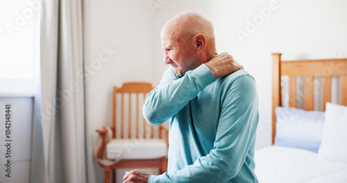 Senior man, bed and shoulder with pain for fibromyalgia, muscle tension or strain in old age home. Elderly, male person or sore neck with pressure for arthritis, tendinitis or joint inflammation