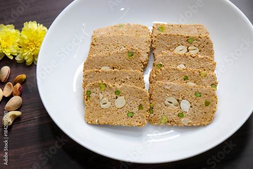 Til gajak, a traditional Indian winter sweet made with sesame seeds, jaggery, ghee, and dryfruits. Crunchy til chikki festive treat for Makar Sankranti. Tilgul. sesame candy. Copy Space. Winter food.