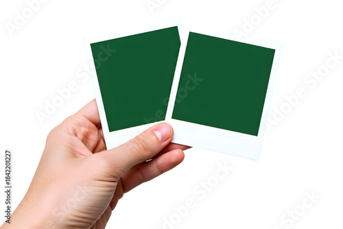 Hand holding two blank polaroid photos isolated on transparent background
