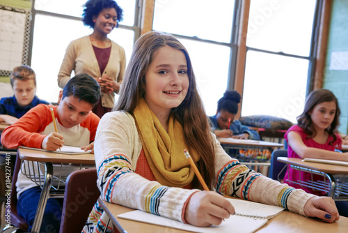 Billede på lærred Portrait, happy girl and learning in classroom with notebook for knowledge, education or assignment