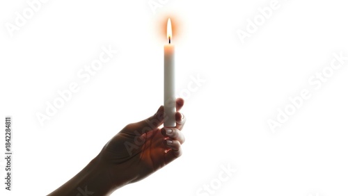 A hand holds a lit white candle against a white background