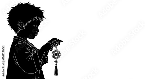 Silhouette of a young boy with spiky hair holding a traditional ornament.