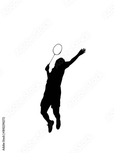 Silhouette of a male badminton player jumping to smash the shuttlecock during a game