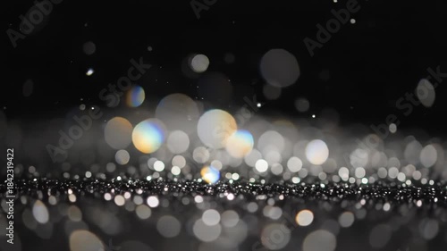 Closeup of glittering bokeh lights on dark surface with a blurred black background