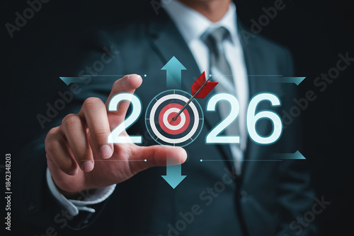 Businessman hand touching target board with arrow and 2026 symbolizing business objectives and strategic planning