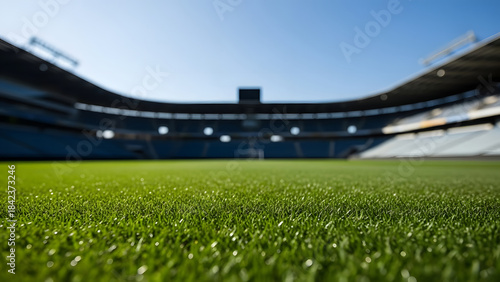 Blurry view of an empty sports stadium with green grass field