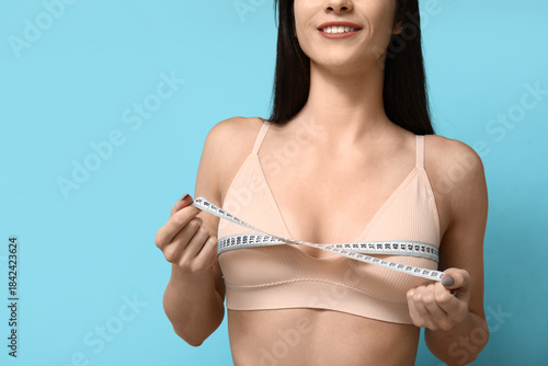 Young woman measuring her b...