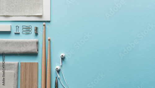 Creative workspace with musical instruments and office supplies arranged on a blue surface