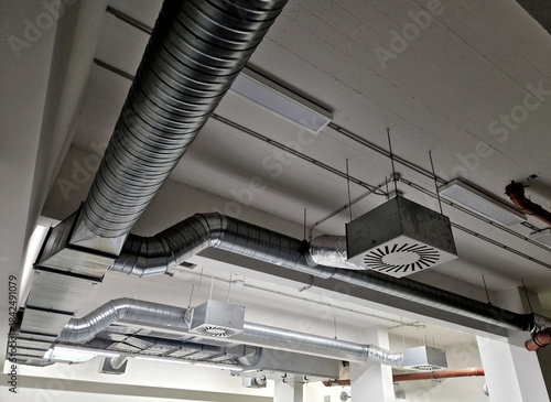 The photo shows an industrial HVAC system, including ductwork and air filters. The system provides air supply and exhaust, conditioning, and distribution throughout the building.