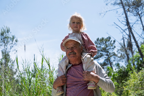  Grandfather Carrying His Granddaughter on His Shoulders Because She Got Tired During a Nature Hike