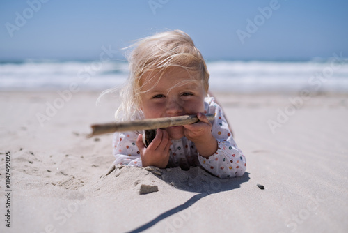 Little Girl Playing Alone in the Sand on the Beach
