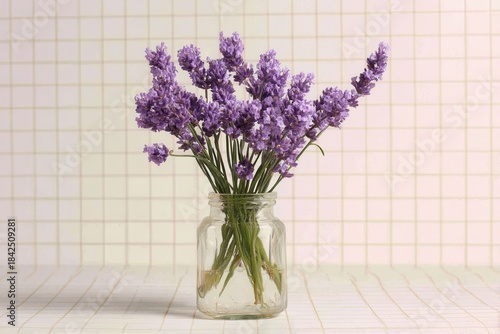 Lavender bouquet in glass jar checkered background