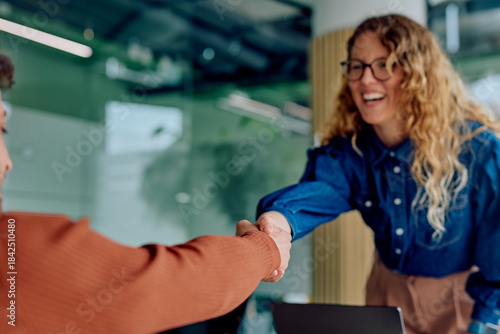 Foto Two businesswomen are shaking hands, celebrating a successful deal and new partn