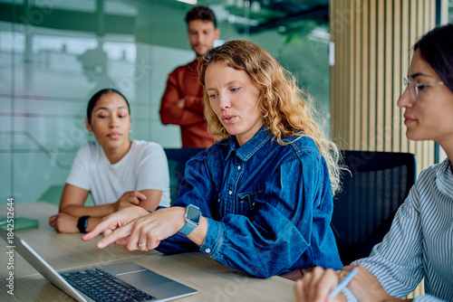 Tableau sur toile Diverse business professionals working together, discussing ideas and pointing a