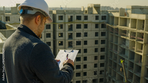 Construction worker or engineer on site checking the building plans on tablet